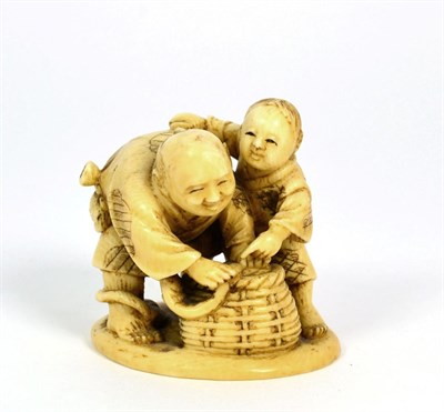 Lot 251 - A Japanese Ivory Netsuke, Meiji period, as an eel fisherman and his son with a basket, signed...