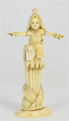 Lot 256 - A Japanese Ivory Okimono, Meiji period, as a boy standing on top of a serpent, on a shaped oval...