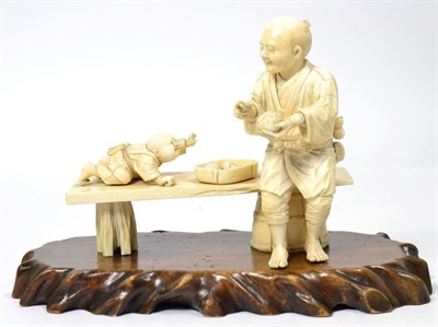 Lot 258 - A Japanese Ivory Okimono, Meiji period, as a man in traditional costume sitting on a bench, a small