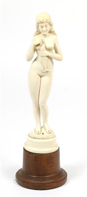 Lot 417 - An Indo-Portuguese Ivory Figure of a Nude, 19th century, standing holding a fish, on a turned...