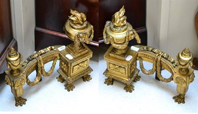 Lot 451 - A Pair of French Gilt Metal Chenets, in Louis XVI style, with flamiform finials issuing from...