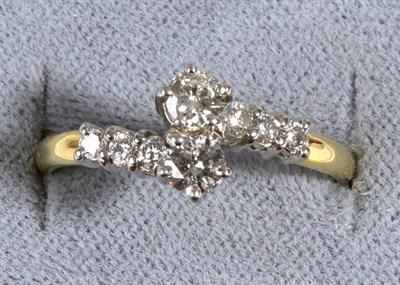 Lot 582 - An 18 Carat Gold Diamond Crossover Ring, two round brilliant cut diamonds in claw settings, to...