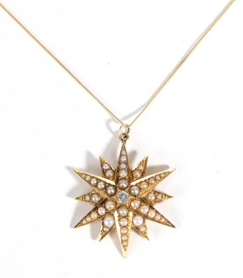 Lot 598 - A Diamond and Seed Pearl Star Pendant, on Chain, a round brilliant cut diamond inset to a seed...