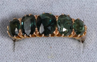 Lot 604 - A 9 Carat Gold Green Tourmaline Ring, five graduated oval cut green tourmaline in claw settings, to