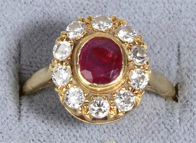 Lot 613 - An 18 Carat Gold Ruby and Diamond Cluster Ring, an oval cut ruby in a rubbed over setting...