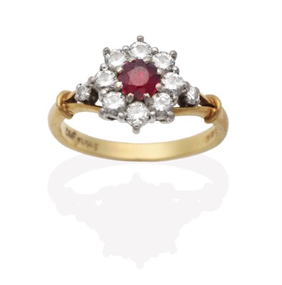 Lot 622 - An 18 Carat Gold Ruby and Diamond Cluster Ring, a round cut ruby in a claw setting within a...