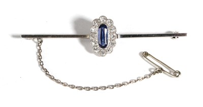 Lot 629 - A Sapphire and Diamond Bar Brooch, an oval cut sapphire within a border of old cut diamonds in...