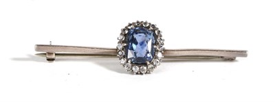 Lot 641 - A Sapphire and Paste Bar Brooch, a cushion cut sapphire in a claw setting, within a border of white