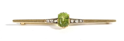 Lot 658 - A Peridot and Diamond Bar Brooch, an octagonal cut peridot in a claw setting, spaced by rose to...