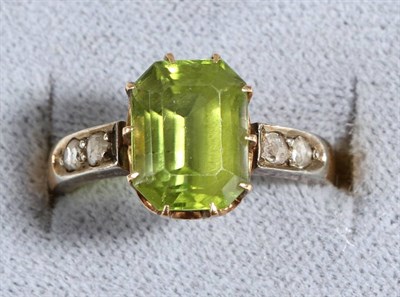 Lot 659 - A Peridot and Diamond Ring, an octagonal cut peridot in a claw setting, to rose cut diamond...