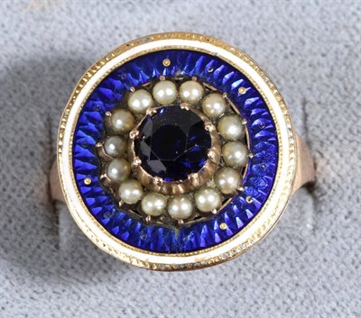 Lot 666 - A Blue Spinel, Seed Pearl and Enamel Ring, a round cut blue spinel in a collet setting within a...