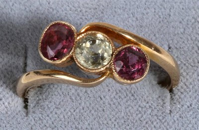 Lot 675 - A Garnet and Chrysoberyl Three Stone Ring, a round cut chrysoberyl in a milgrain setting...