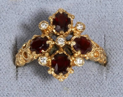 Lot 679 - An 18 Carat Gold Garnet and Diamond Ring, four oval cut garnets spaced by round brilliant cut...