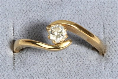 Lot 687 - An 18 Carat Gold Solitaire Diamond Ring, a round brilliant cut diamond in a claw setting, to scroll