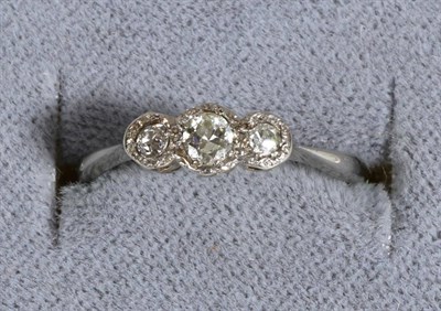 Lot 688 - A Three Stone Diamond Ring, graduated old cut diamonds in illusion settings, to knife edge...