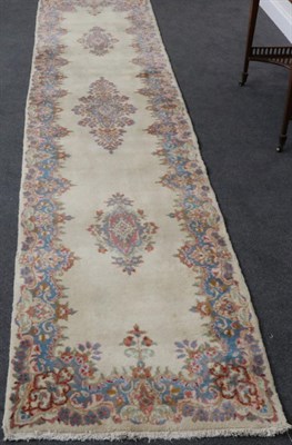 Lot 1309 - Narrow Kirman Runner South East Iran, circa 1950 The plain ivory field with a column of...