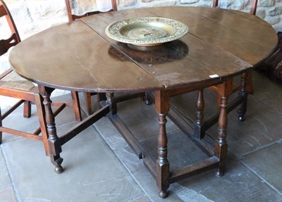 Lot 1388 - An Early 18th Century Oak Six-Seater Gateleg Table, with two rounded drop leaves to form an...