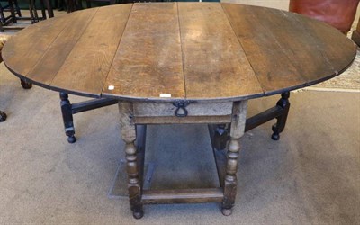 Lot 1392 - An Early 18th Century Oak Dropleaf Dining Table, with two rounded drop leaves to form an oval,...