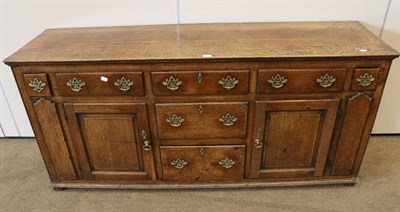 Lot 1406 - A George III Oak Enclosed Dresser, late 18th century, with an arrangement of five frieze...