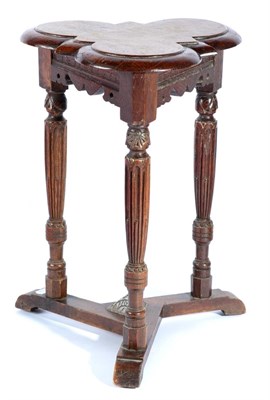 Lot 1412 - A Victorian Carved Oak Triform Occasional Table, raised on turned and stop-fluted supports...