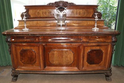 Lot 1515 - A Late 19th Century Continental Walnut Sideboard, with carved pediment above a staged top, the base