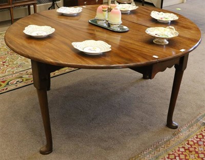 Lot 1520 - A George III Mahogany Dropleaf Six-Seater Dining Table, with two leaves to form and oval above...