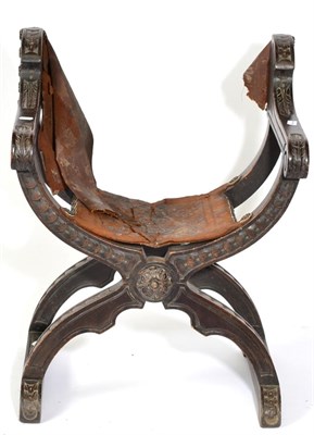 Lot 1540 - A Carved Walnut Folding Chair, in 17th century style, with worn leather seat and carved hand grips