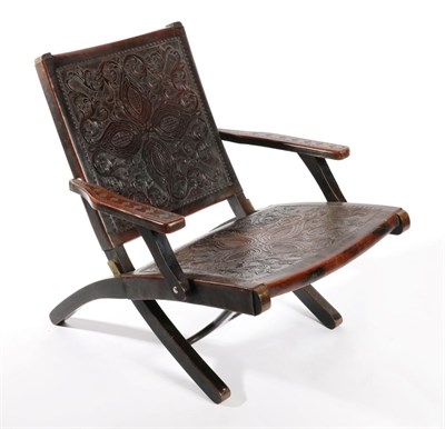 Lot 1557 - A Brown Leather Folding Armchair, circa 1900, with embossed back support and conforming seat,...