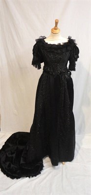 Lot 46 - A Circa 1890 Black Satin Two Piece Evening Gown, comprising a fitted short sleeved bodice with...