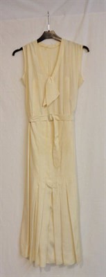 Lot 61 - A Circa 1920's Cream Silk Sleeveless Tennis Dress, with a v neck top and attached ties, pleated...