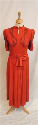 Lot 86 - Circa 1940's Orange Crepe Dress with short sleeves and beaded circular detailing to the...