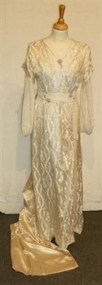 Lot 1140 - An Edwardian Cream Silk Wedding Gown, long chiffon sleeves and waistband with applied pearl...