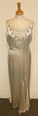 Lot 1141 - Circa 1928 Cream Satin Sleeveless Full Length Wedding Dress with pleated detailing to the...