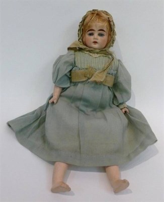 Lot 1001 - A Bisque Shoulder Head Doll, with blue intaglio eyes, blond wig, open mouth, on a fabric body...