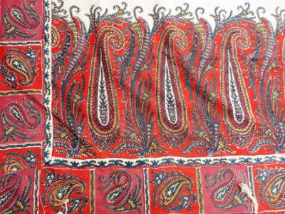 Lot 1034 - Early 19th Century Woven Paisley Shawl with a cream centre, red and blue ground border, 150cm...
