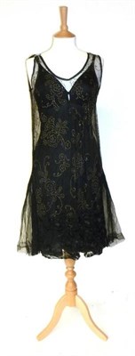 Lot 1160 - Circa 1920's Beaded Shift Dress on a black net decorated with silver beads and sequins with a cream