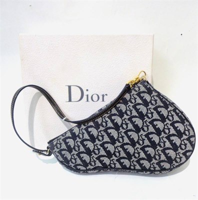 Lot 1191 - Christian Dior Saddle Shaped Bag with blue leather strap and logo fabric, 22cm by 16cm, in original