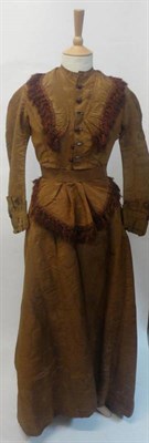 Lot 1247 - 19th Century Brown Silk Dress with buttons to the front, full skirt, tassel trims to the bodice and