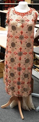 Lot 1138 - A Circa 1920's Bead and Sequin Shift Dress on a dark cream silk mount, decorated overall with...