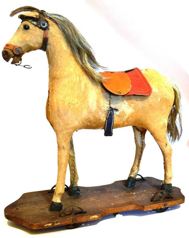 Lot 1017 - A 19th Century Carved Wood and Tan Pony Skin Pull-Along Horse with leather bridle and...