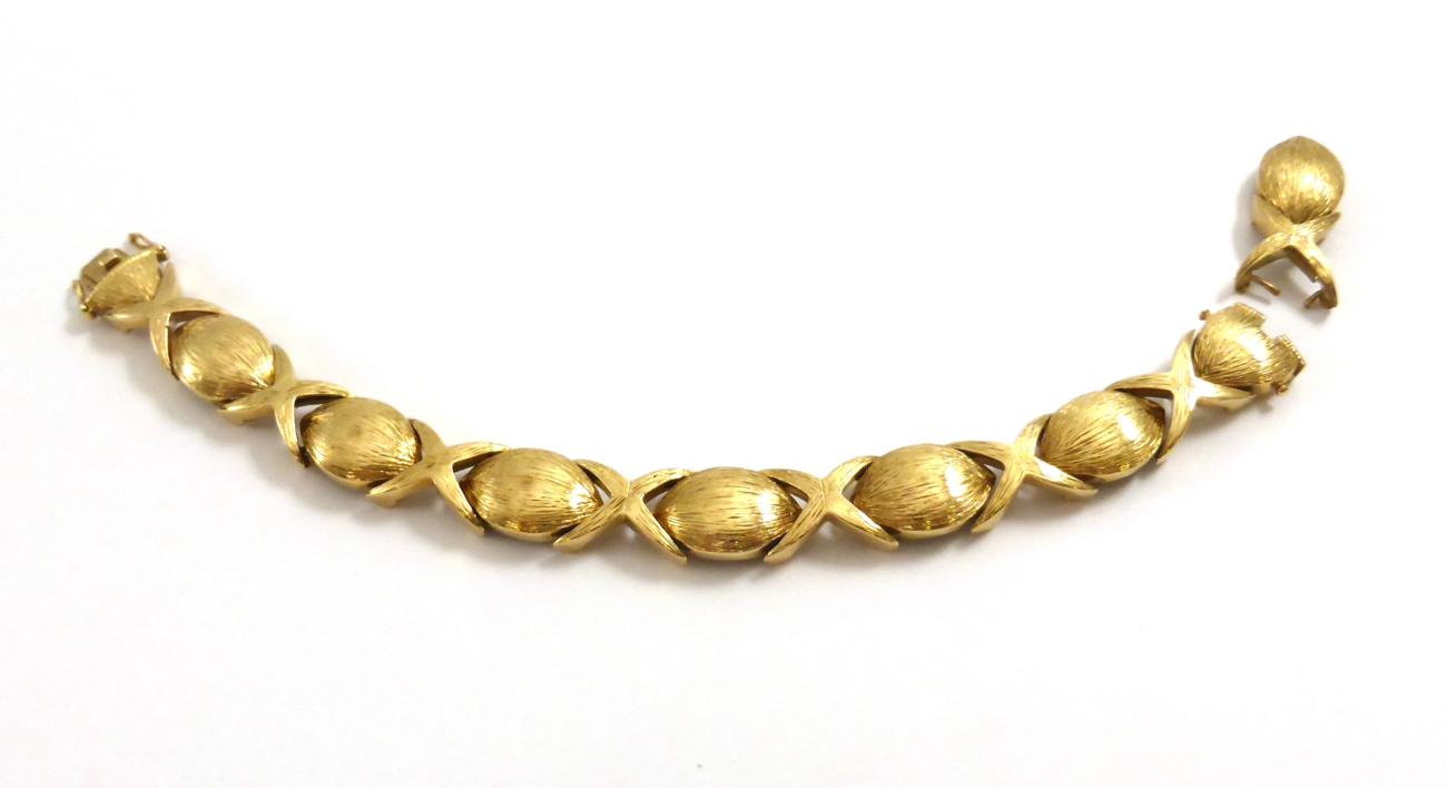 Lot 2150 - A 9ct Gold Bracelet, 1973, textured ovoid and cross shaped links alternate, length 17.2cm  NB...