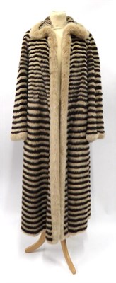 Lot 2171 - A Reversible Long Mink Coat, with tiered horizontal alternating pelts of light and dark brown,...