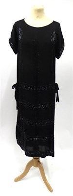 Lot 2191 - Circa 1920s Black Silk Crepe Shift Dress, with capped sleeves, black bead appliques in a grid...