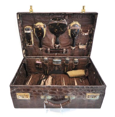 Lot 2208 - An Early 20th Century Crocodile Dressing Case, with gilt metal locks stamped 'Patent 137.194', with