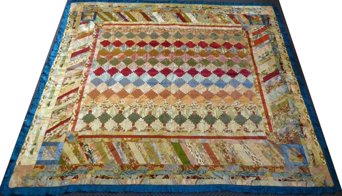 Lot 2012 - A Decorative Patchwork Cover, incorporating log cabin design to the centre, with a blue...