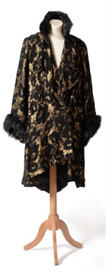 Lot 2115 - Circa 1920s Opera or Evening Coat, in black textured floral pattern woven with gold threads,...
