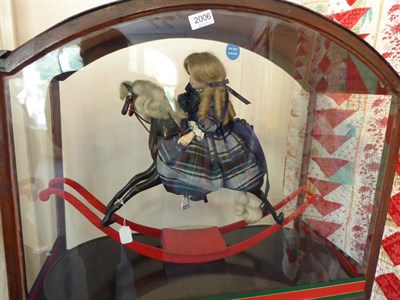 Lot 2006 - Automaton of Young Girl Riding a Rocking Horse in a Glazed Case, comprising a bisque socket...