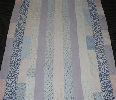 Lot 2055 - Early 20th Century Patchwork Quilt, incorporating blue, purple and pink printed cottons, cream...