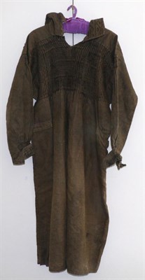 Lot 2139 - A Mid 19th Century Brown Linen Farmers Smock, with smocking and embroidered detailing to the...