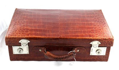 Lot 2072 - An Early 20th Century Crocodile Leather Suitcase, with chrome coloured locks, with a brown...